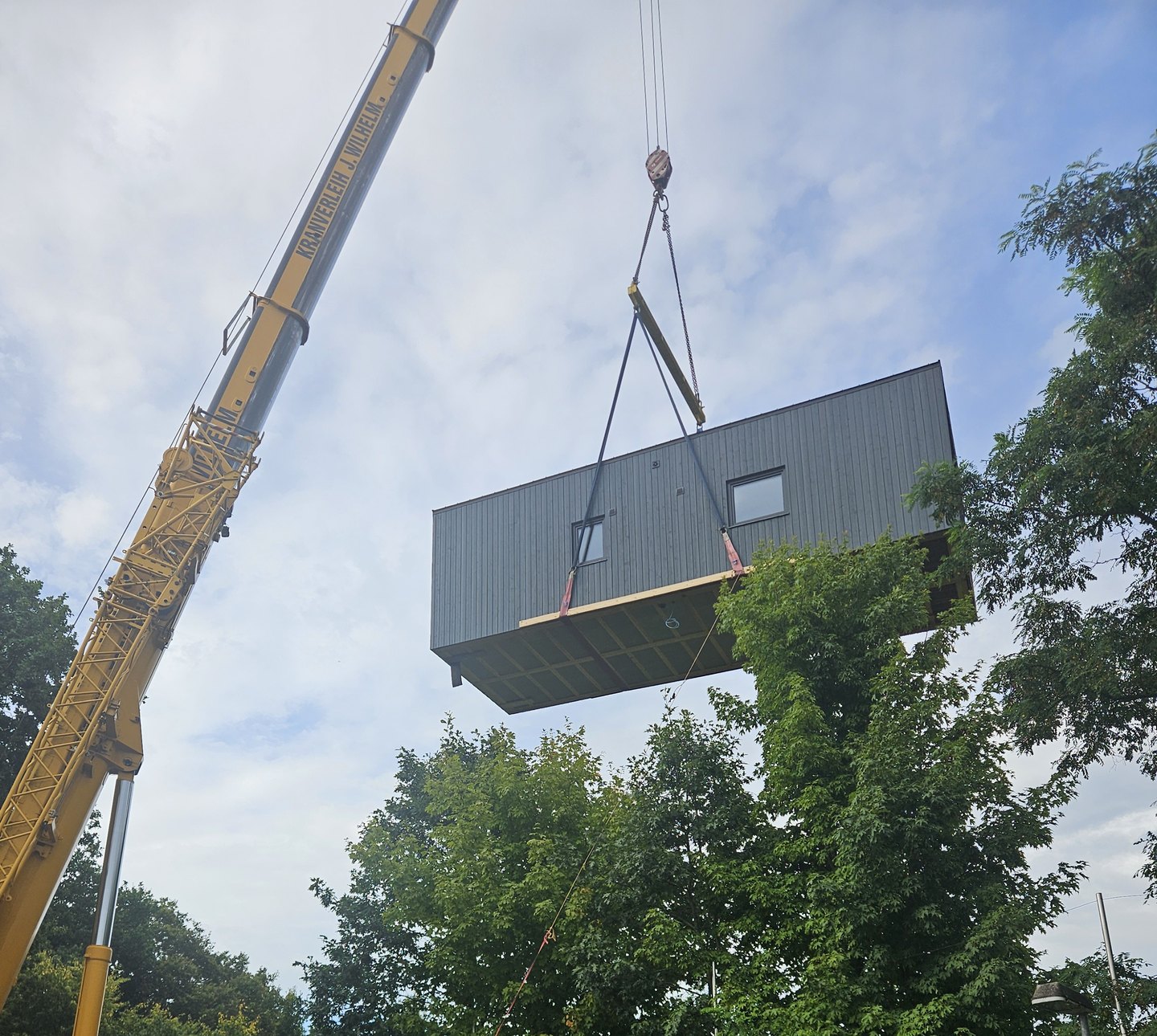 A Fixmodul module suspended from a mobile crane on delivery day